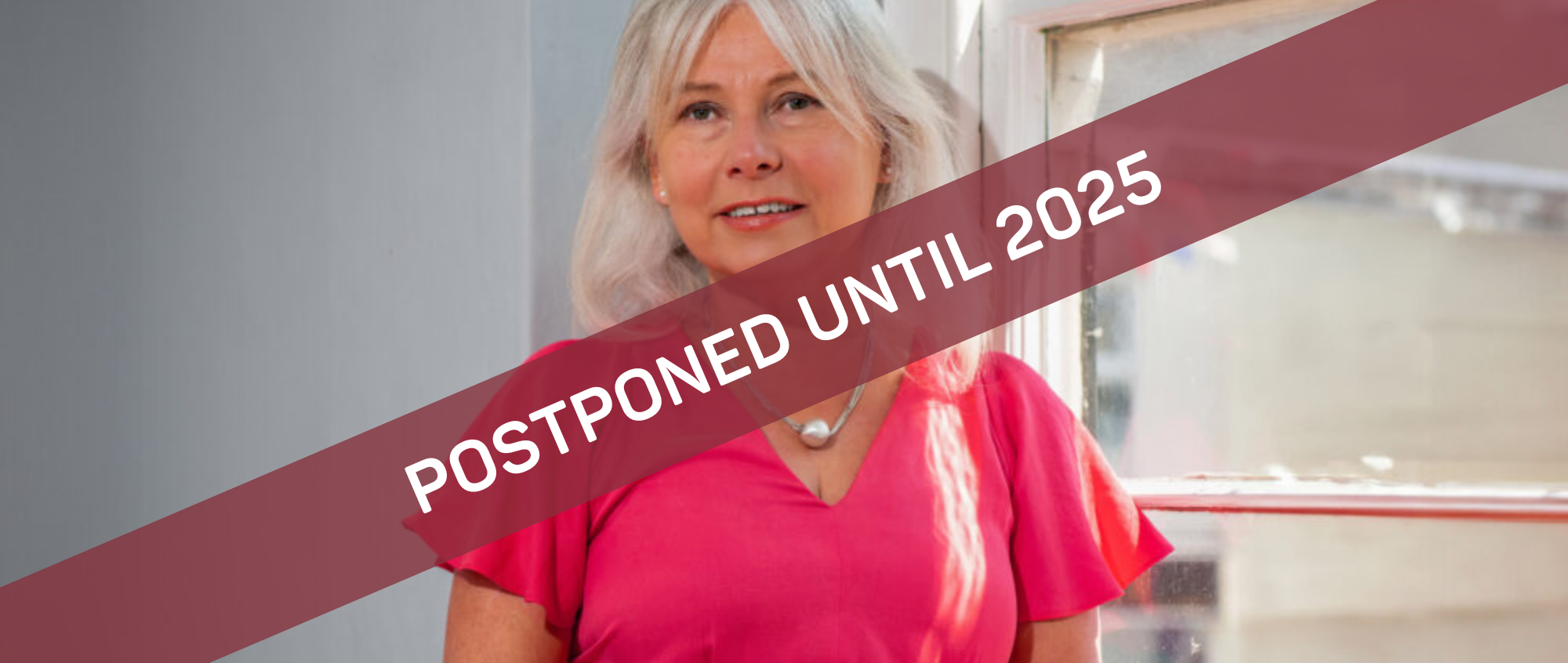 Photo of Melita Thomas with postponed until 2025 banner