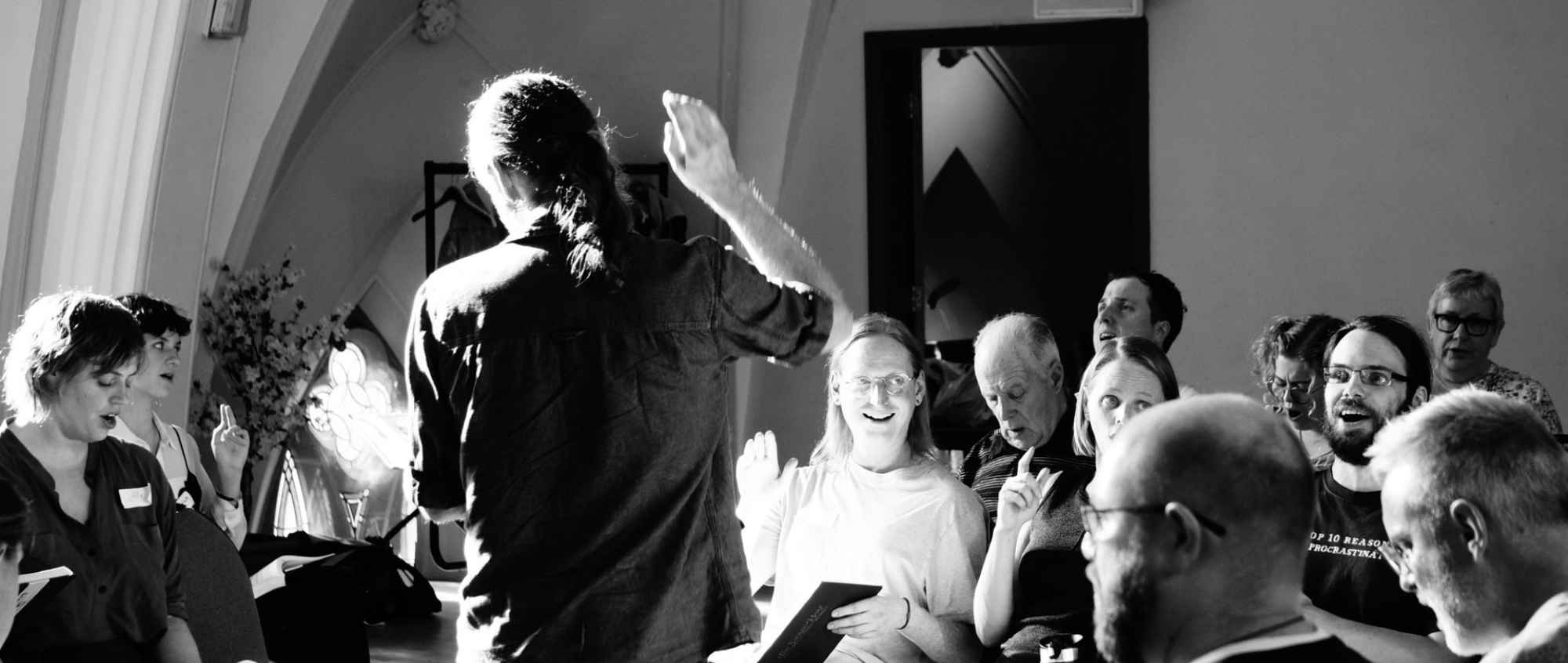 Black and white photo with a group of people singing