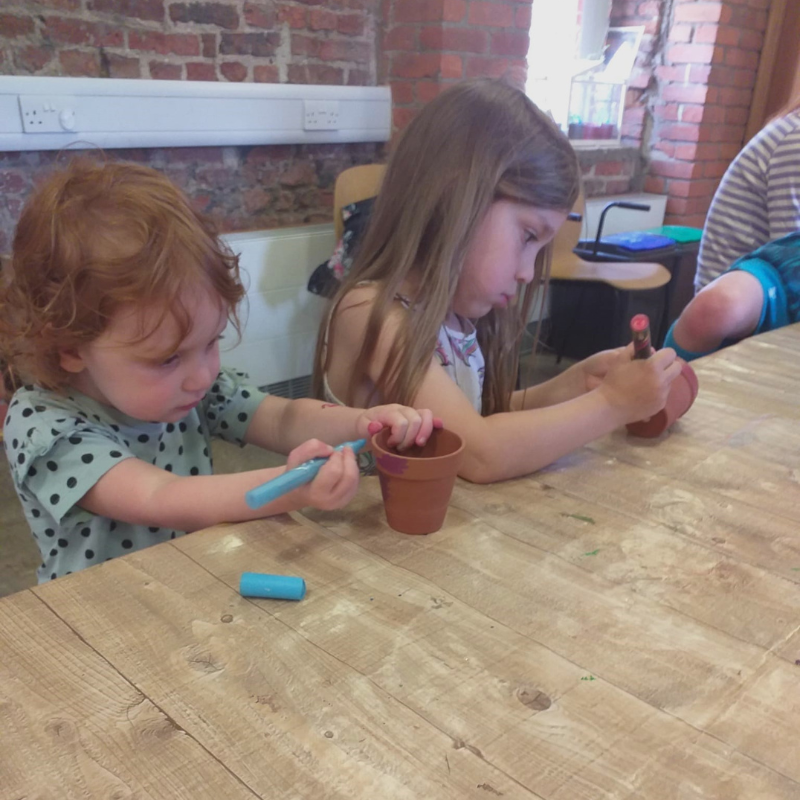 Children decorating plant pots