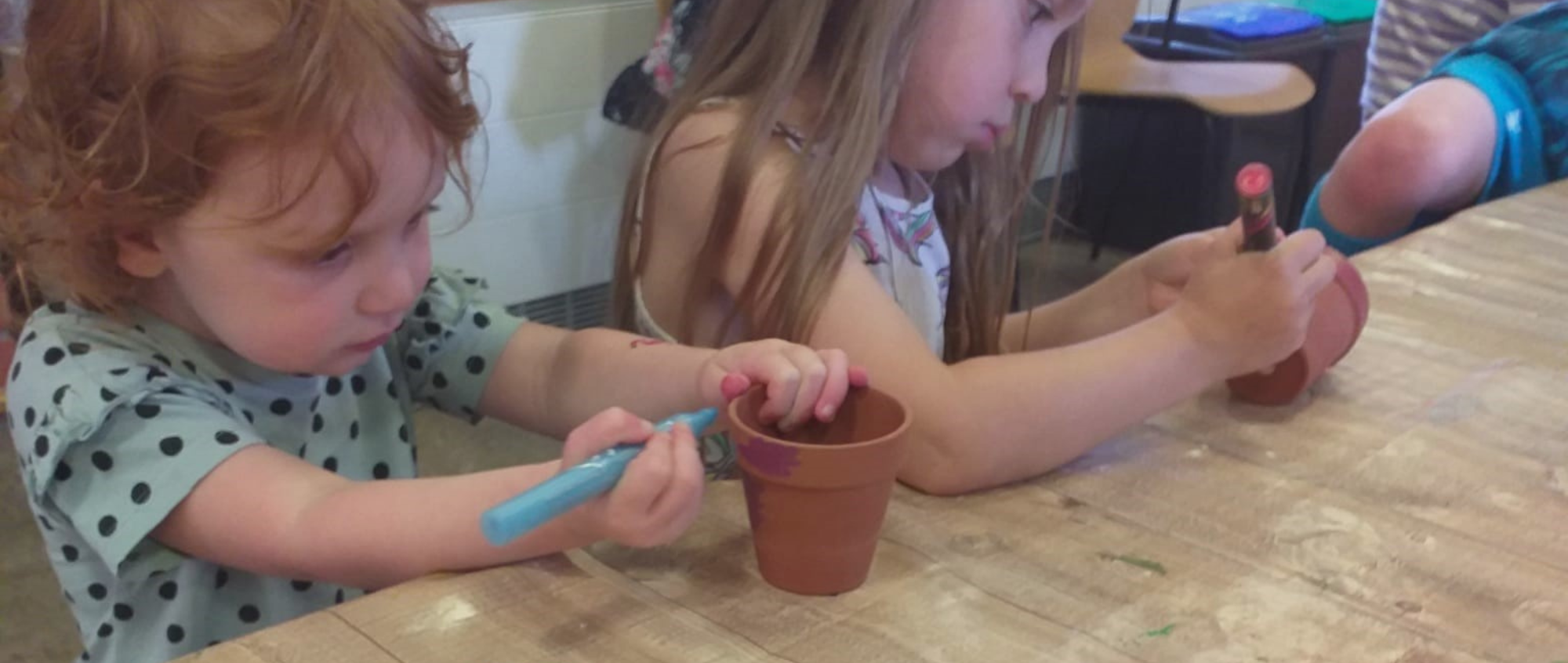 Children decorating plant pots