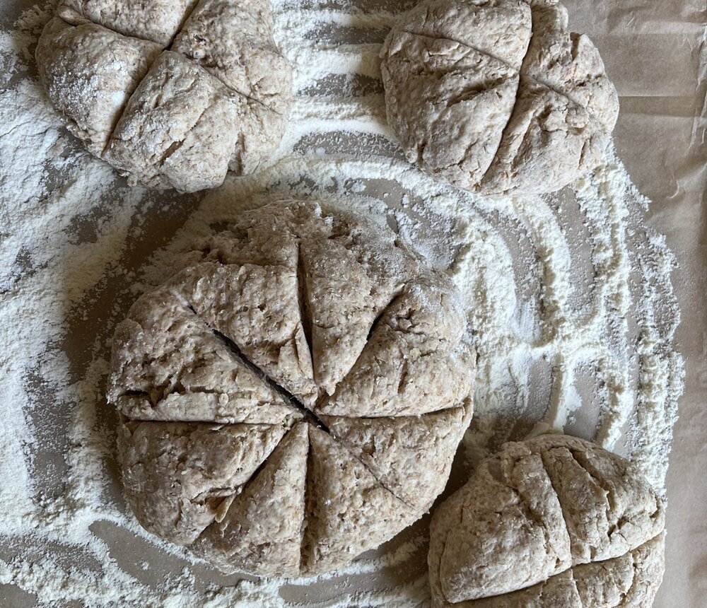 four uncooked rustic looking loaves on a floury board