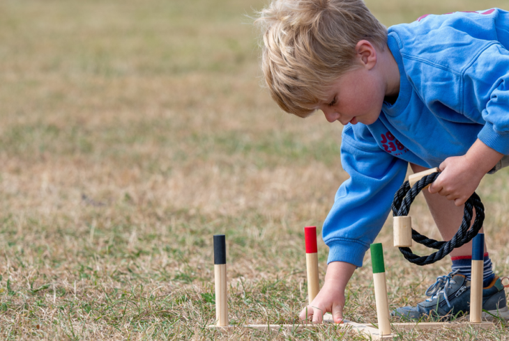 Child playing game outside on grass